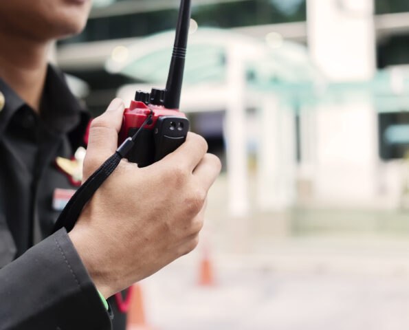 Security guard uses radio communication for facilitate traffic. Traffic Officers use walkie talkie to maintain order in the parking lot in Thailand.