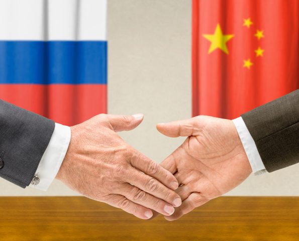 Representatives of Russia and China shake hands