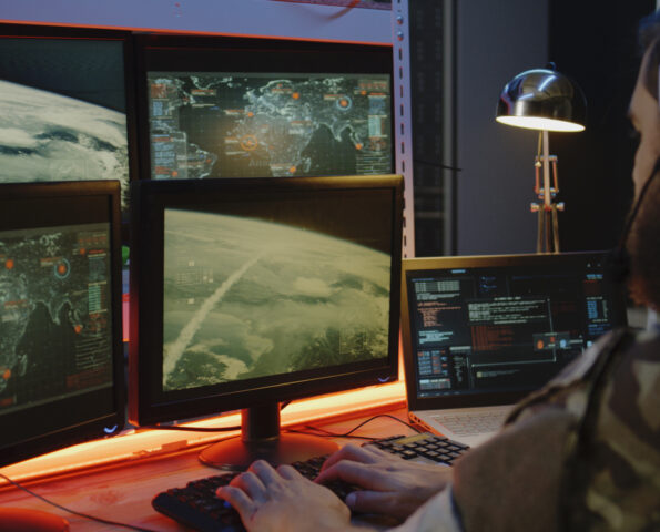 Medium close-up of a soldier overseeing rocket launch on computer