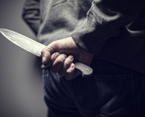 Person holding a knife behind their back