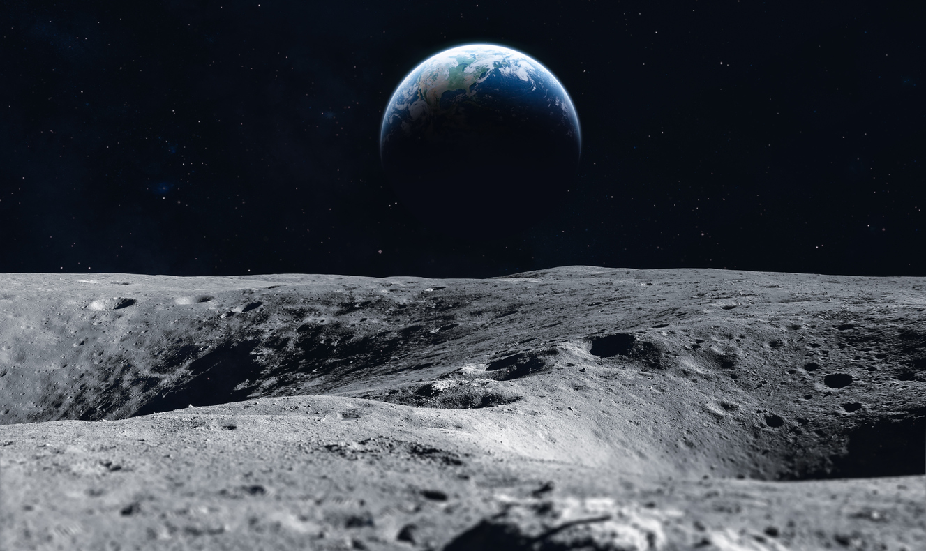 An image taken from the surface of the moon. The Earth appears in the distance over the horizon.